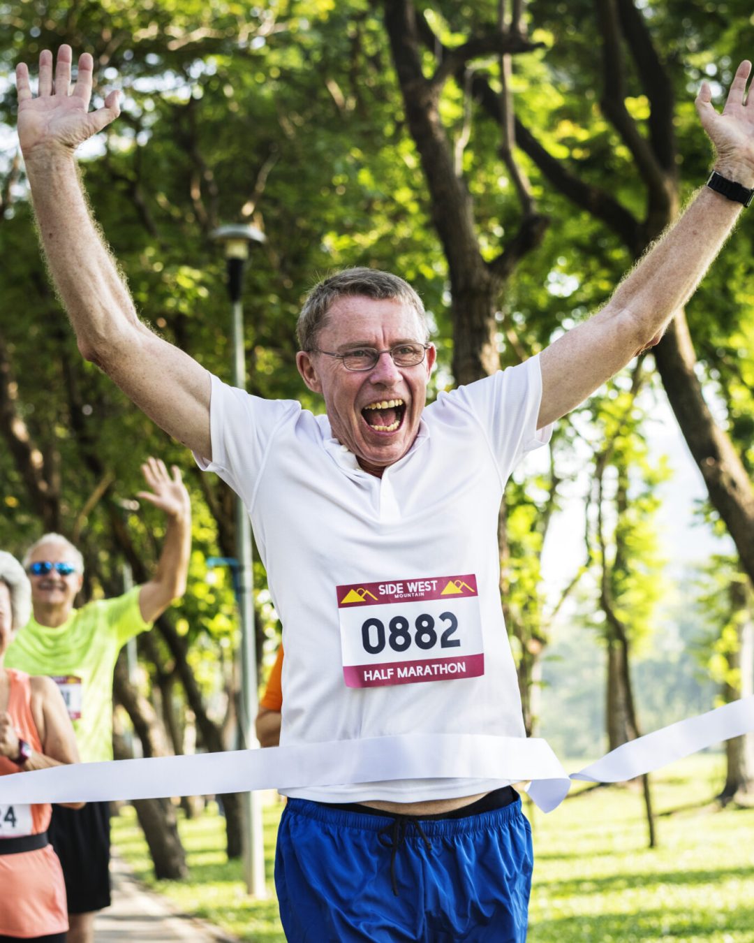 Happy senior running through the finish line