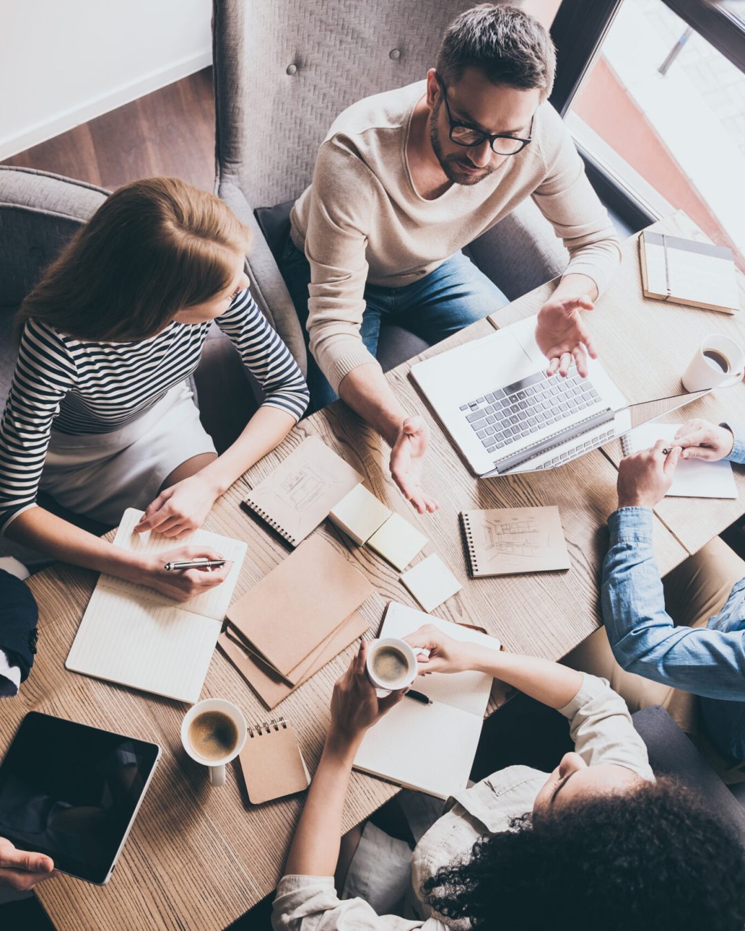 Business meeting. Top view of buiness team brainstorming while sitting at the office table together