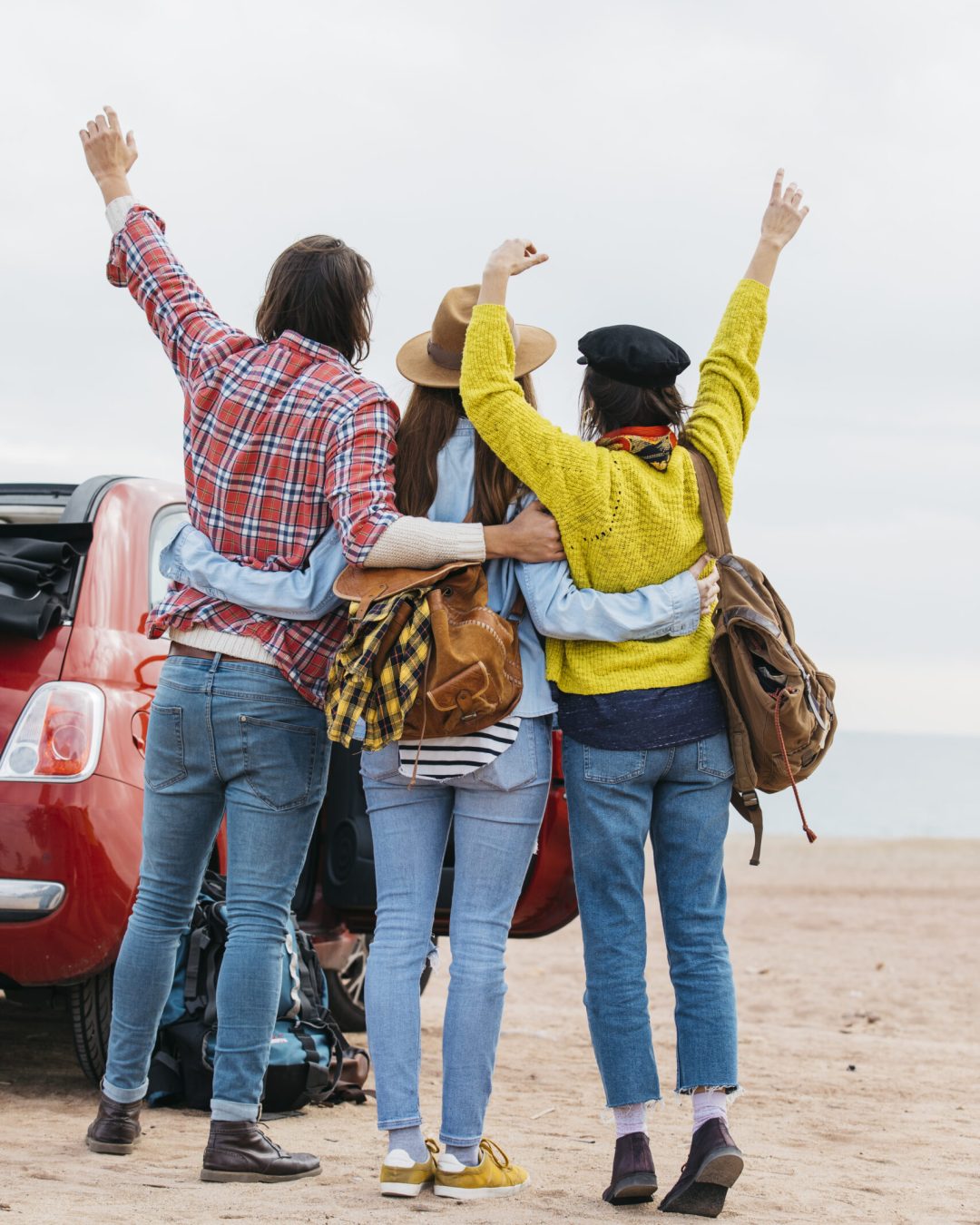 man-women-embracing-near-car-sea-beach